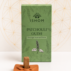 ISHOM Patchouli Oudh Smudge Incense Bricks with terracotta holder and natural incense bricks displayed on a white table.