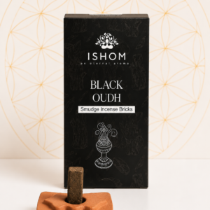 ISHOM Black Oudh Smudge Incense Bricks with terracotta holder and natural incense bricks displayed on a white table.