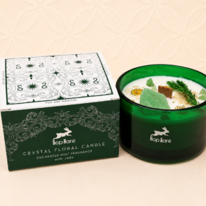 Hop Hare Crystal Magic Flower Candle The Magician with Spearmint & Lime fragrance, genuine Jade crystal, dried flowers, and a wooden wick in a deep green glass container beside its gift box.