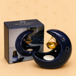 Midnight blue crescent moon ceramic oil burner with a hanging golden bowl and matching gift box on a warm neutral background.